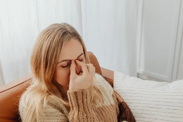 a woman holding her nose